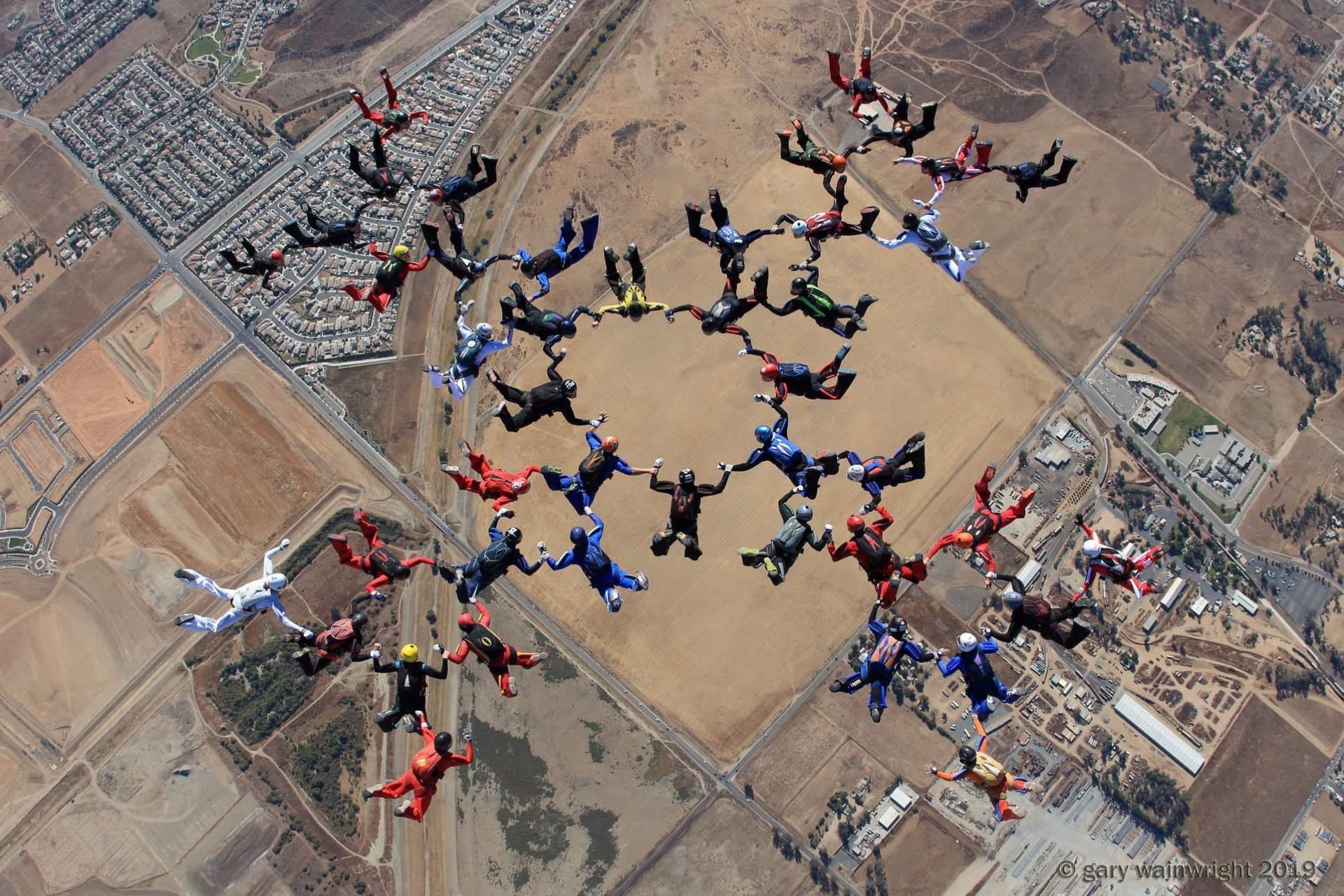 Gran formación de paracaidistas vista desde arriba, con anillos concéntricos