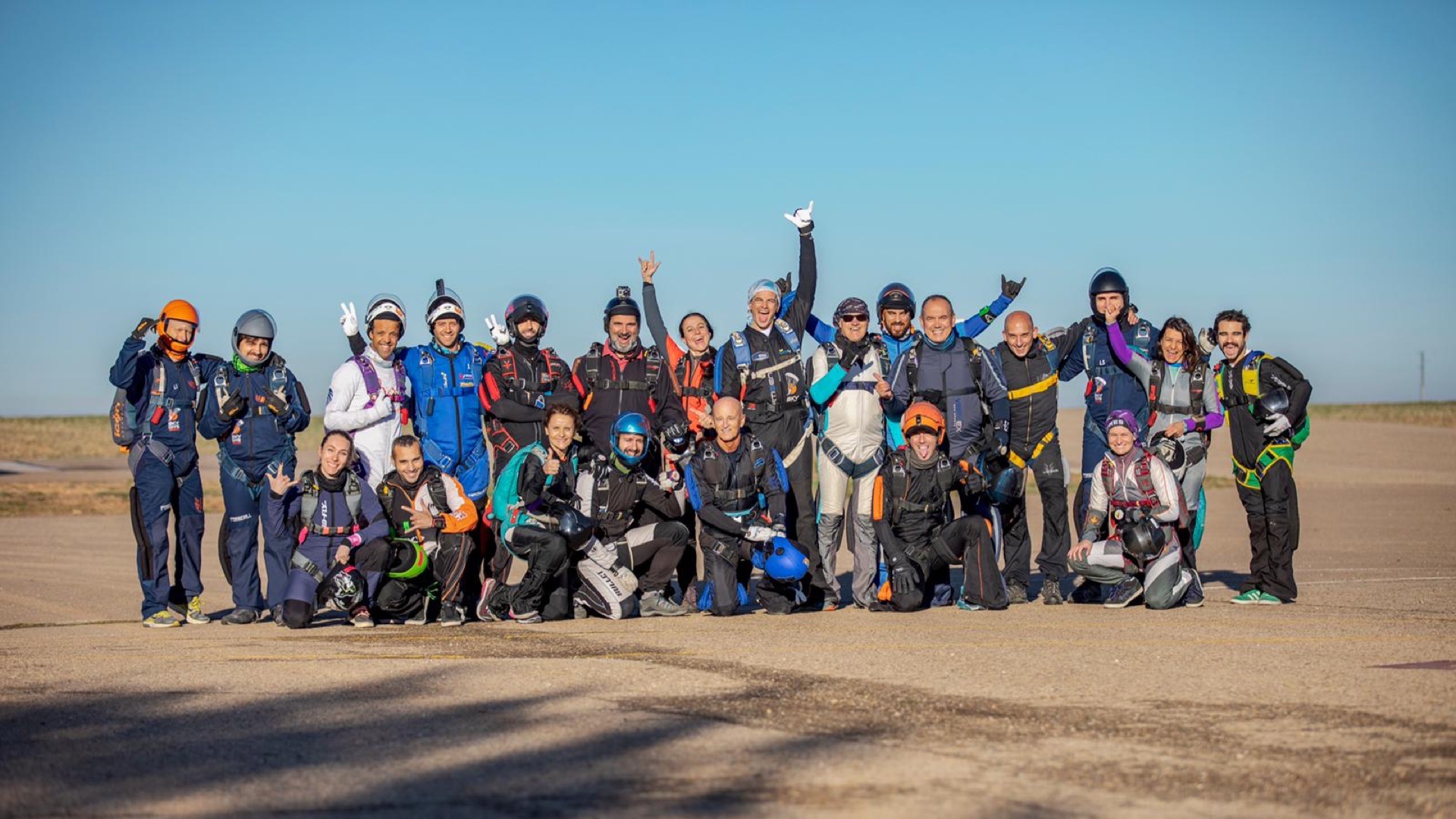 Grupo de paracaidistas posando en la pista tras un salto